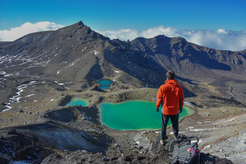 Hombre mirando el paisaje, los lagos y el camino.