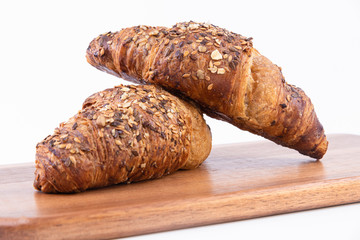 A pair of freshly baked Croissant on a cutting board