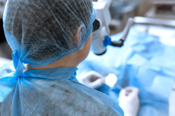 A professional ophthalmologist performs eye surgery with a microscope. The doctor inserted the...