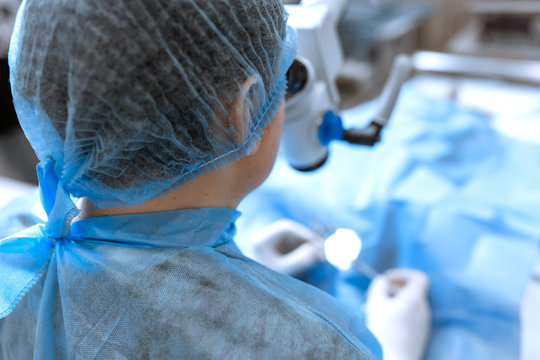 A professional ophthalmologist performs eye surgery with a microscope. The doctor inserted the dilator into the eye, washes and removes pus with a syringe. Endoscopic eye surgery. medical equipment