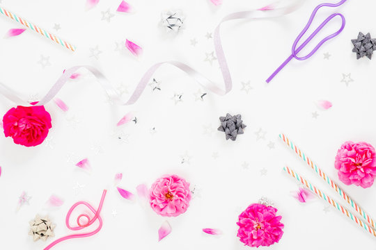 Summer party background with festive feminine accessories, ribbon, pink rose flower buds and petals on white background. Flat lay, top view, overhead
