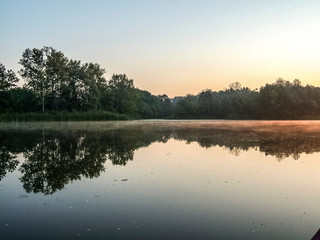 Fototapeta premium Sunset over the river. Red sun. Beautiful evening background