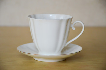 White porcelain cup and saucer on wooden table