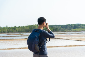 Good looking photographer man taking photo at the sea.