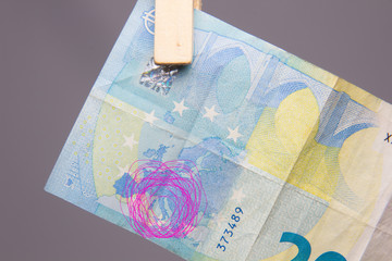 Dinero en billetes de euro, colgados por pinzas de madera en una frágil cuerda.
