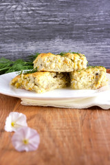 Delicious homemade casserole of zucchini, rice and cheese on a white plate on a wooden background.