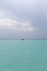 Fototapeta premium A guy is standing on a rock in the middle of the ocean. The power of the ocean
