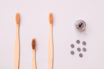 Bamboo toothbrush and dry tooth paste or toothpaste tablets on blue background. Zero waste, ecological concept.