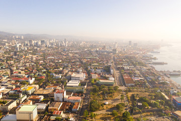 Cityscape in the morning. Streets and seaport of the city of Cebu, Philippines, top view. Panorama of the city with houses and business centers.