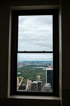 Fototapeta New York skyline of Manhattan and central park as seen from a high point as an aerial view. View through a window from the inside