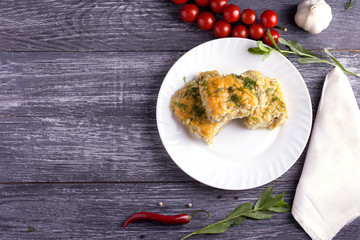 Delicious homemade casserole of zucchini, rice and cheese on a white plate on a wooden background.
