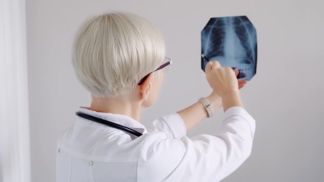 Doctor looks at x-ray picture. Diagnostics. Hospital and medicine
