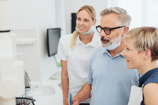 Zahnarzt und Patientin schauen auf ein Röntgenbild in der Praxis