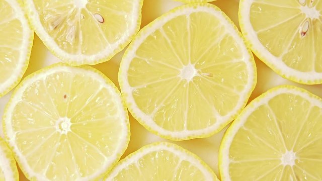 Fruits pattern, close shot. Rotative background. Yellow lemon slices, abstract background. Lemon slices structure. Art installation of fresh juicy fruits cutted into slices
