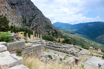 Fototapeta na wymiar Scenic panoramic view from the top to ruins of ancient greek temple of apollo in Delphi, Greece and Pleistos river valley and parnassus mountain