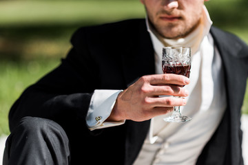cropped view of victorian man holding wine glass with drink