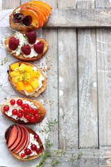 Obraz na płótnie Canvas Variety of mini cream fresh sandwiches with fruits and berries 