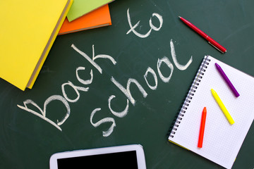 School board with the inscription "back to school", bright books and notepad