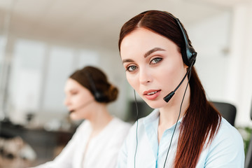 technical support office worker with a headset answering in a call center and talking with clients.