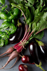 Vegetables on the black background. Organic foods and fresh vegetables. Beets, buklazhany, onions and herbs basil.