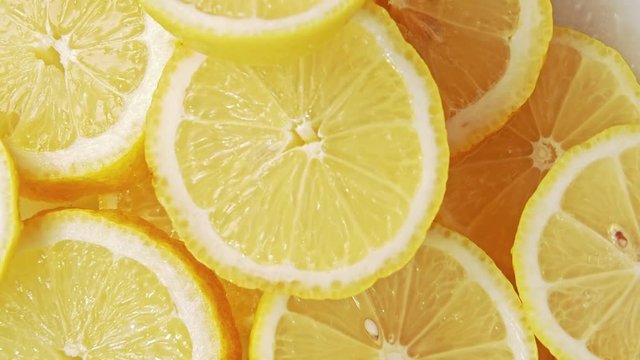 Yellow lemon slices piled togather, close shot. Rotative background. Abstract pattern of lemon structure. Composition of yellow slices. Selective soft focus