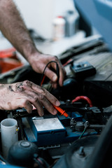 cropped view of car mechanic working in car service