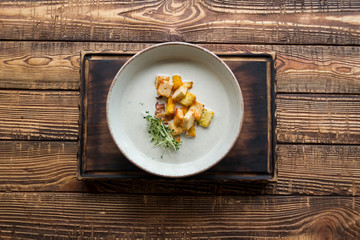 Cream soup in a plate, on a wooden table.