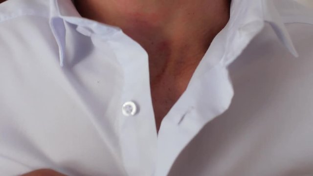 Close-up of a guy with a beard in a white shirt who stretches the buttons on the shirt. 4k. 4k video