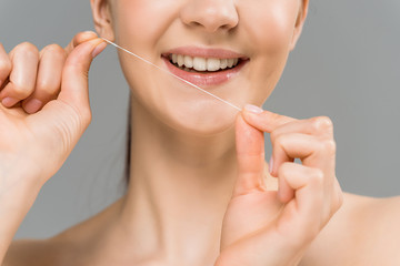 cropped view of cheerful woman holding dental floss near teeth and smiling isolated on grey - obrazy, fototapety, plakaty