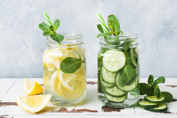 Detox water for healthy lifestyle. Fresh water in jar with lemon, cucumber and mint on wooden table.
