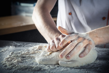 Chef prepares the dough with flour. Hands kneading raw dough Horizontal. Copy space. Gluten free dough for pasta, bakery or pizza. Baker workplace. Chef makes dough. Culinary, cooking, bakery concept