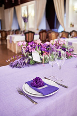 Table setting with white plates, flowers, wineglasses and cutlery on table, copy space. Menu mockup, place setting at wedding reception. Table served for wedding banquet in restauran