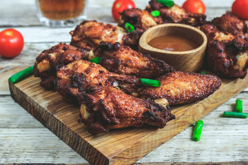 Grilled chicken wings on wooden background.