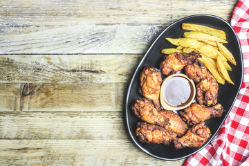 Grilled chicken wings on wooden background.