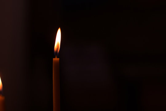 soft focus candle fire illumination in black background, atmospheric wallpaper pattern picture with empty copy space for text
