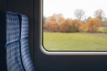 German train chairs and autumn view on the window