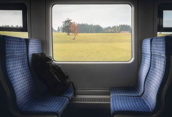 Train interior with chairs and backpack at window