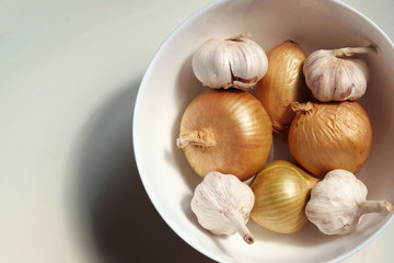 Onions and grlick in the white porcelain cup