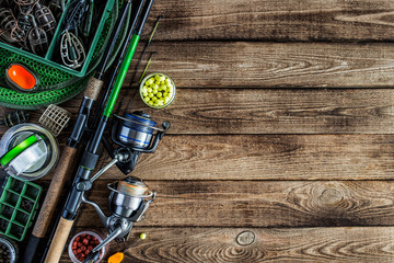Fishing feeder and reel.Fishing tackle background.Fishing feeder- hooks and lures on darken wooden...