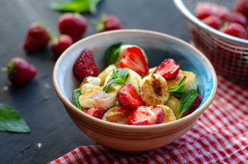 mini cheese pancakes with honey and strawberries on black background. proper nutrition healthy dessert