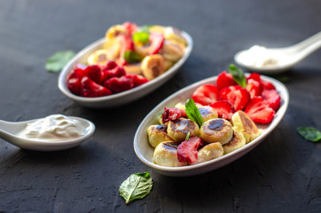 mini cheese pancakes with honey and strawberries on black background. proper nutrition healthy dessert