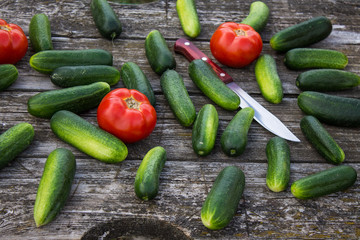 Fresh cucumbers tomatoes and peppers on an old wooden table