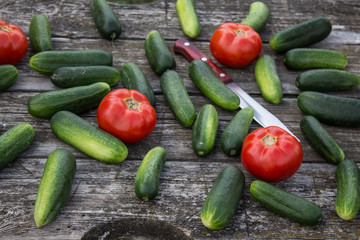 Fresh cucumbers tomatoes and peppers on an old wooden table