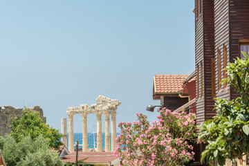 Schöne Straße mit vielen Blumen und Aussicht auf den berühmten Apollon-Tempel in Side in der...