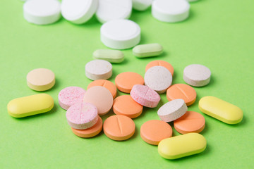 Obraz na płótnie Canvas Medicines pills, drugs and antibiotics on a green background. Medicine and health care.