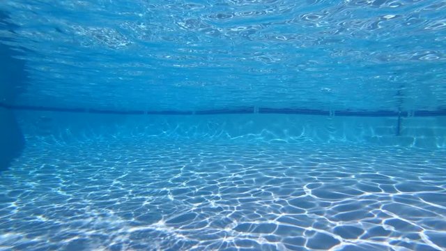 Slow motion underwater sunlight patterns in clean empty swimming pool.  Shot at 240 frames per second.  
