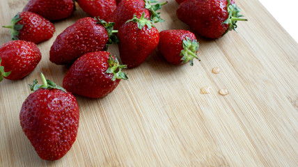 bright red ripe fragrant strawberries on a wooden Board on a white background on a Sunny summer day