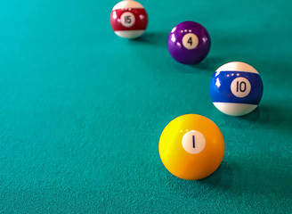 4 ball from a pool or billiard on a billiard table with a number 1 ball in the foreground with space for text.