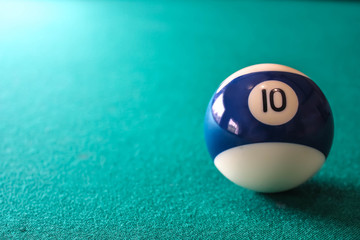 Striped color blue and white billiard ball with number 10 on green table background with place