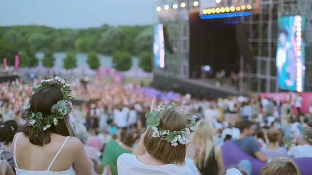 Women are watching concert at open air music festival